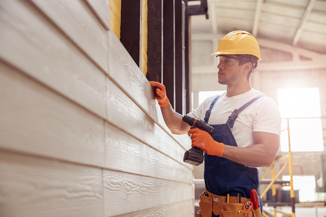 Handsome,Young,Man,Builder,Installing,Exterior,Wood,Siding Handsome young man builder installing exterior wood siding