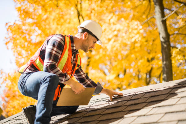 A man with hard hat standing on steps inspecting house roof Roof Inspection Near Me Brentwood PA: